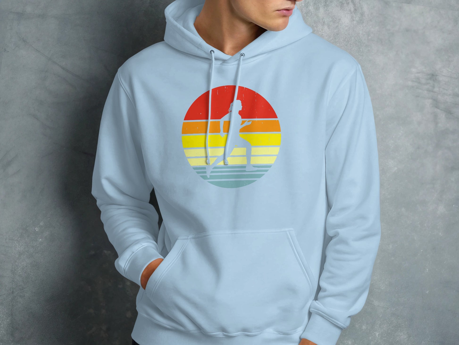 Light blue hoodie with a circular graphic of a runner against a sunset.