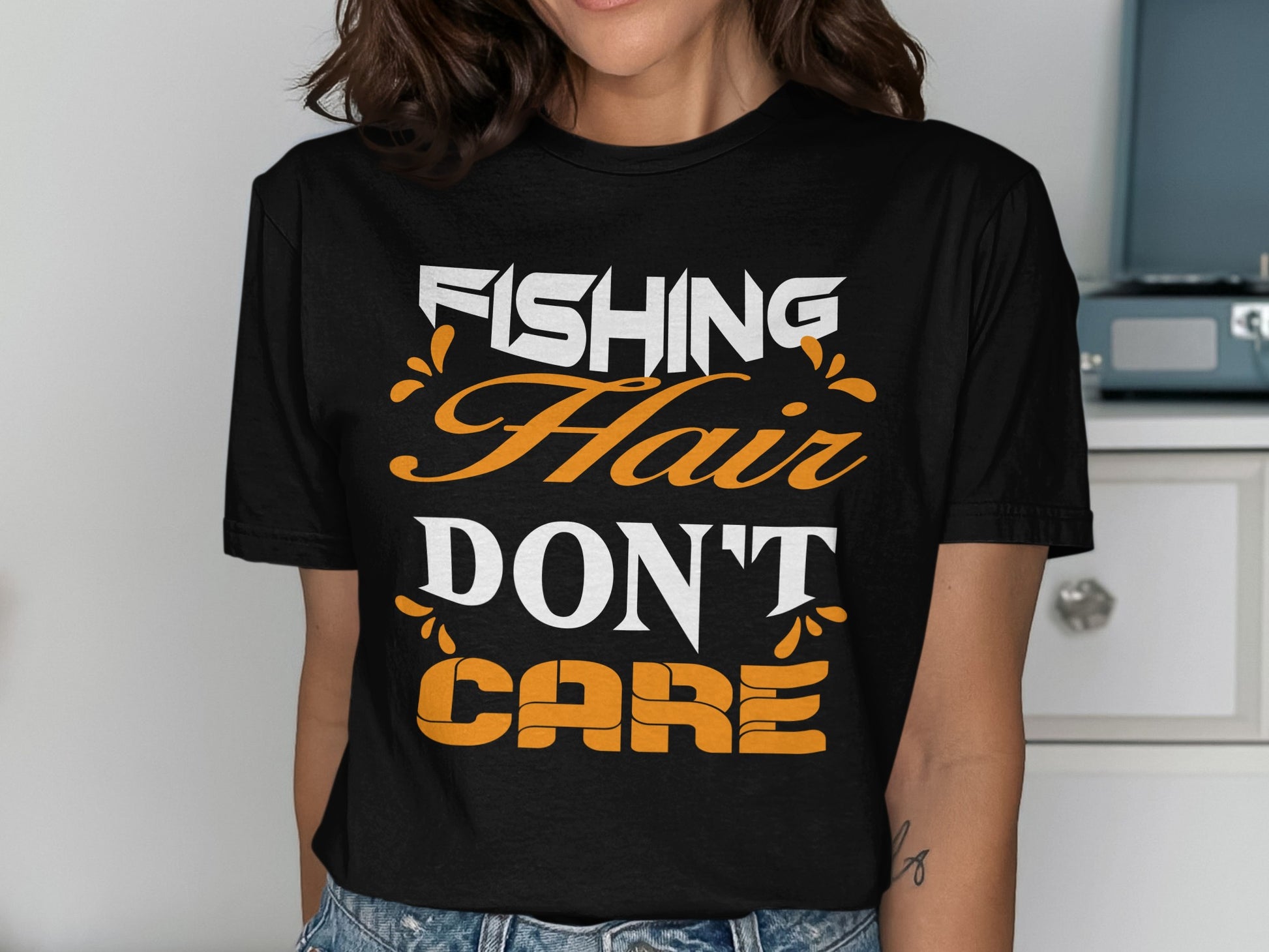 Black t-shirt with white and orange text reading "FISHING HAIR DON'T CARE".