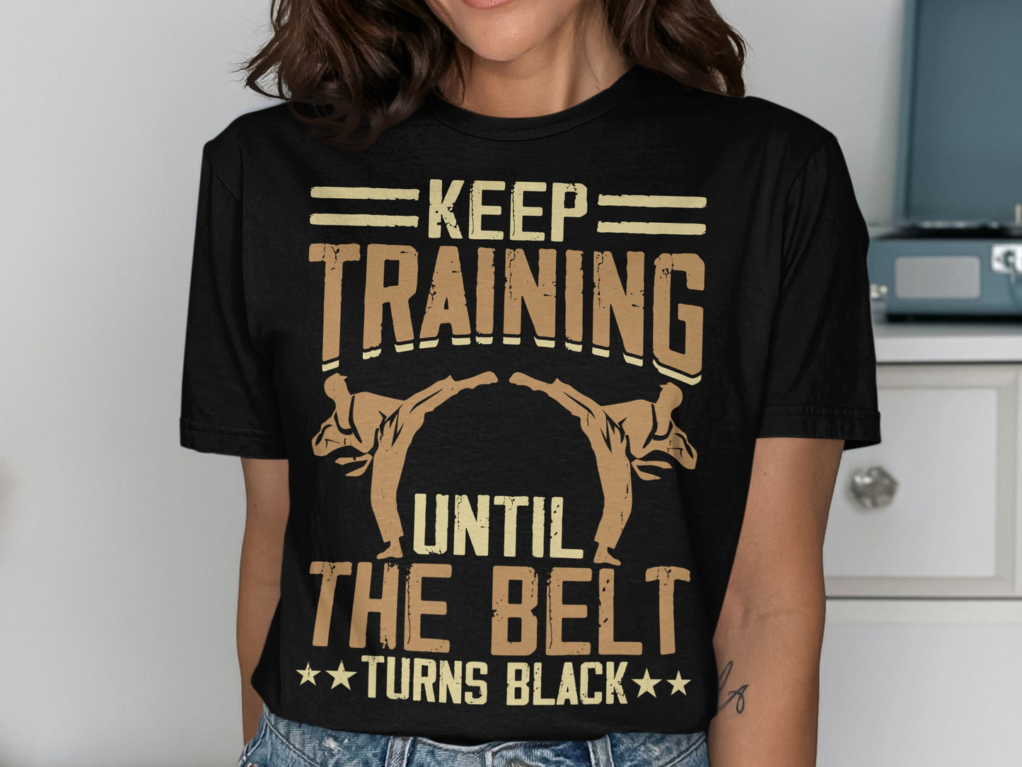 Black t-shirt with "Keep Training Until The Belt Turns Black" text and martial artists.