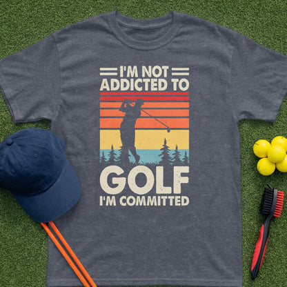 T-shirt with text "I'm Not Addicted To Golf, I'm Committed" and golf imagery.