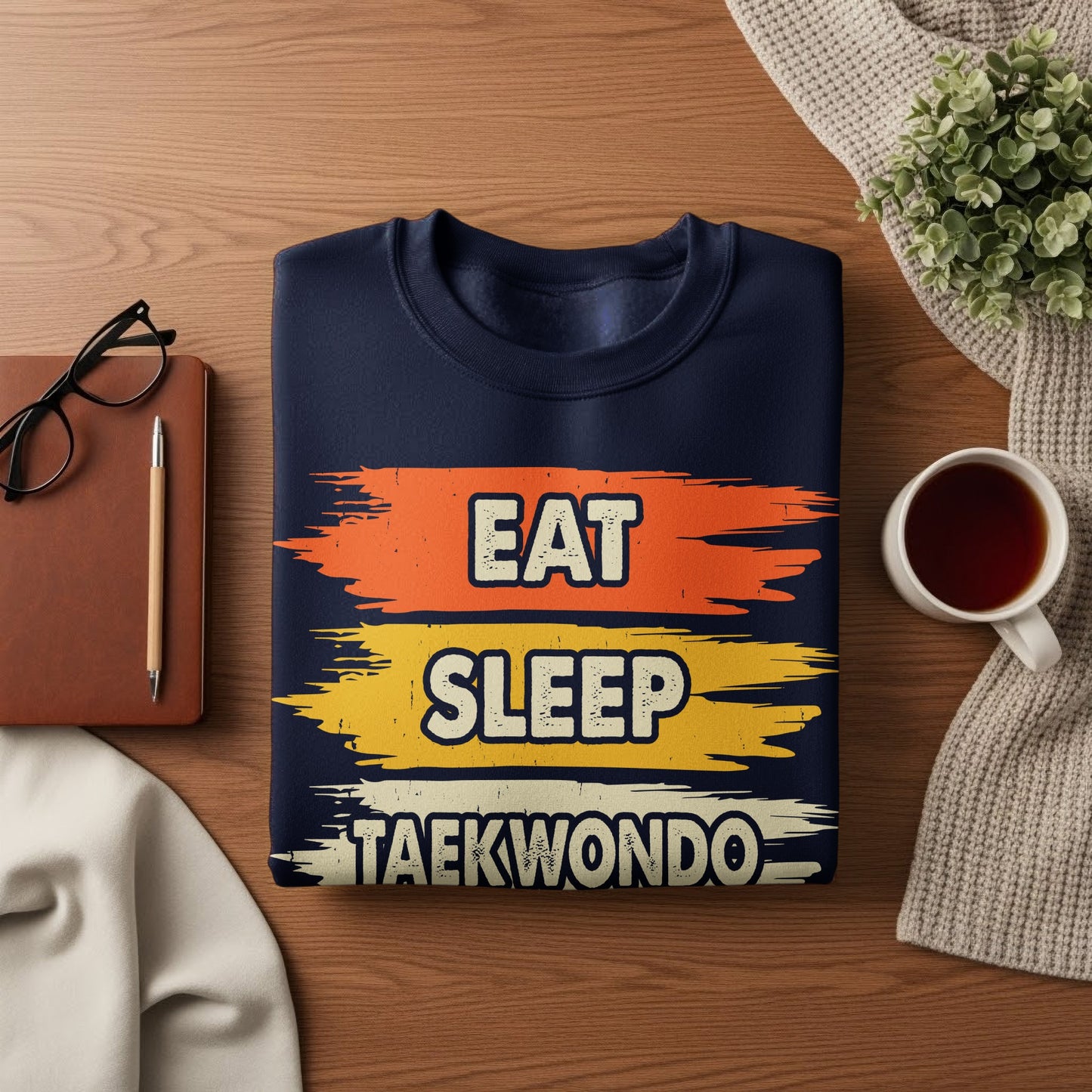 Navy sweatshirt with "Eat Sleep Taekwondo" in distressed text across three colorful stripes.
