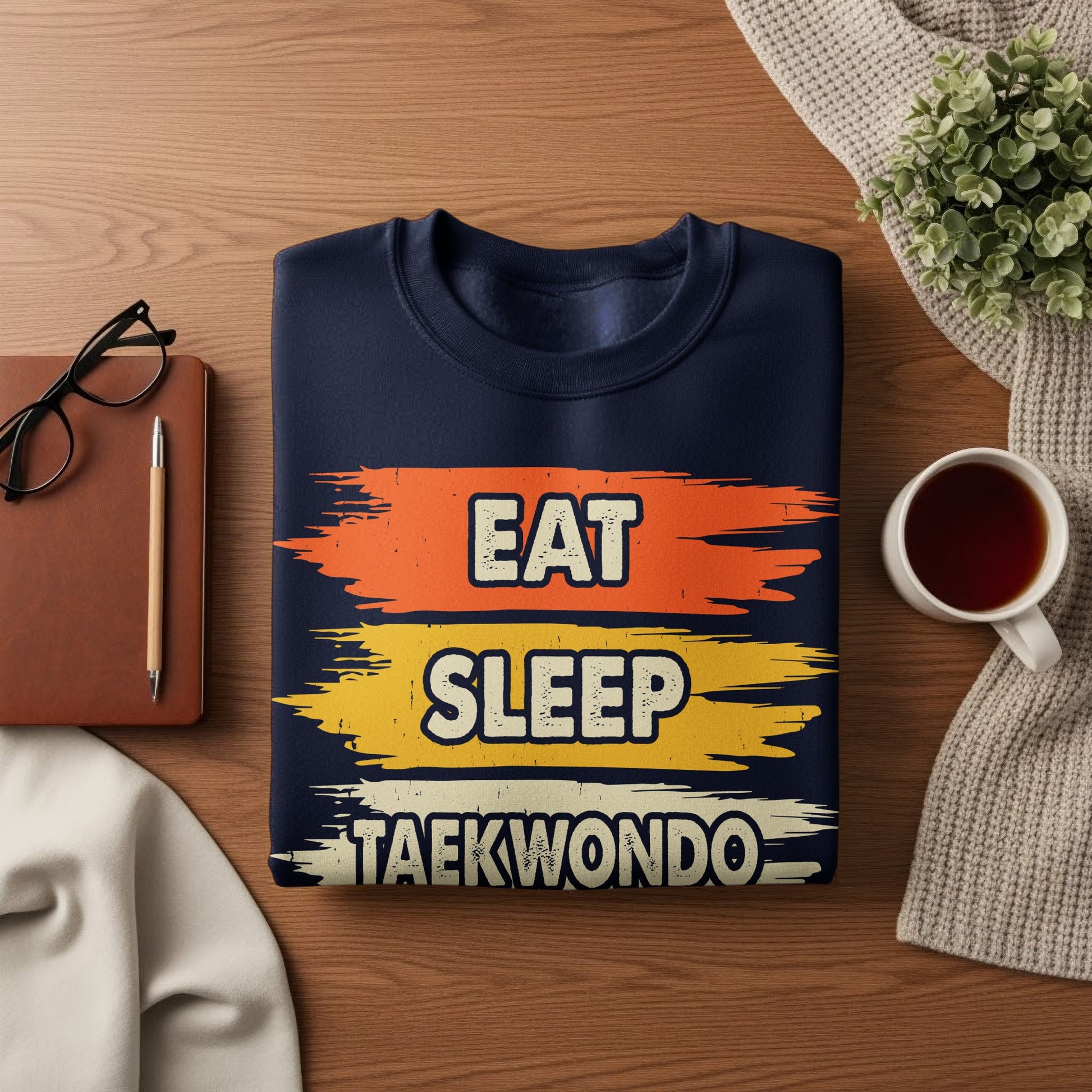Navy sweatshirt with "Eat Sleep Taekwondo" in distressed text across three colorful stripes.