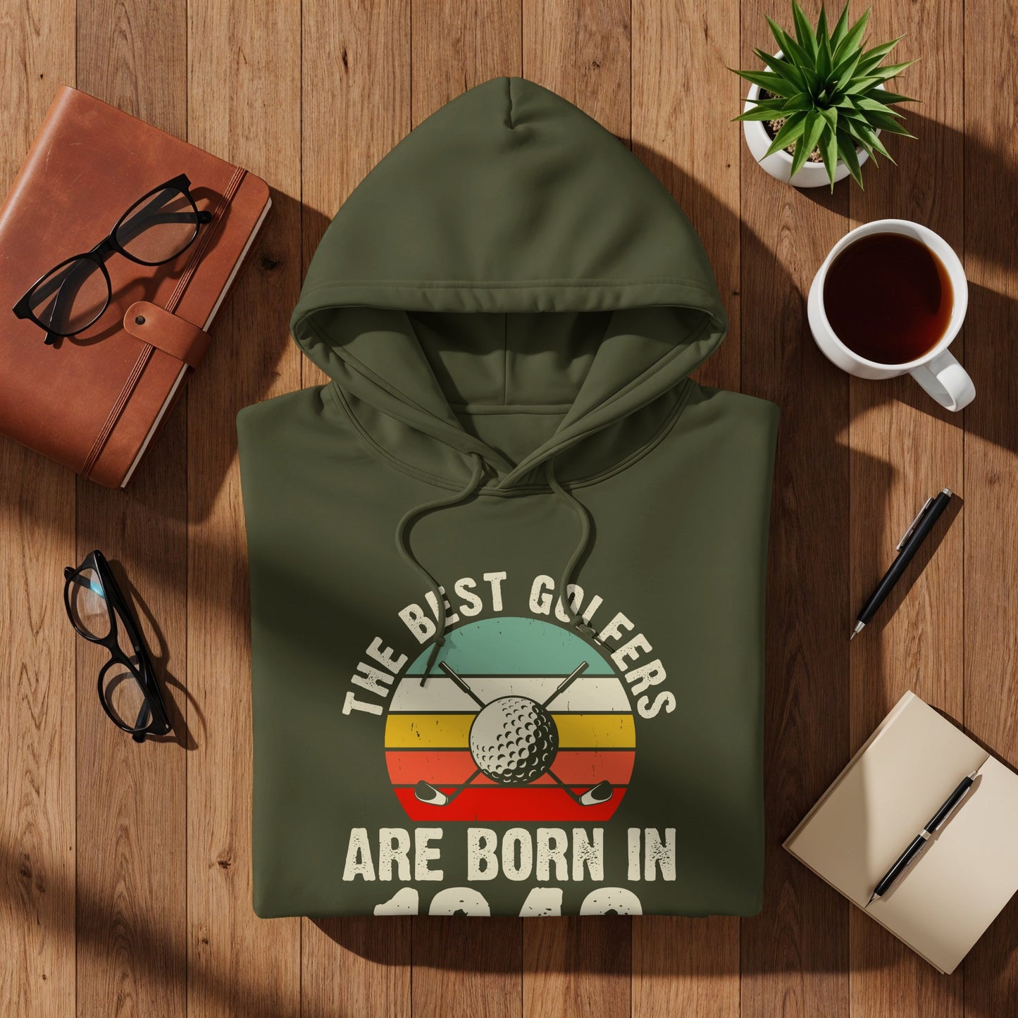 Olive green hoodie with text "The best golfers are born in 1980" and golf imagery.
