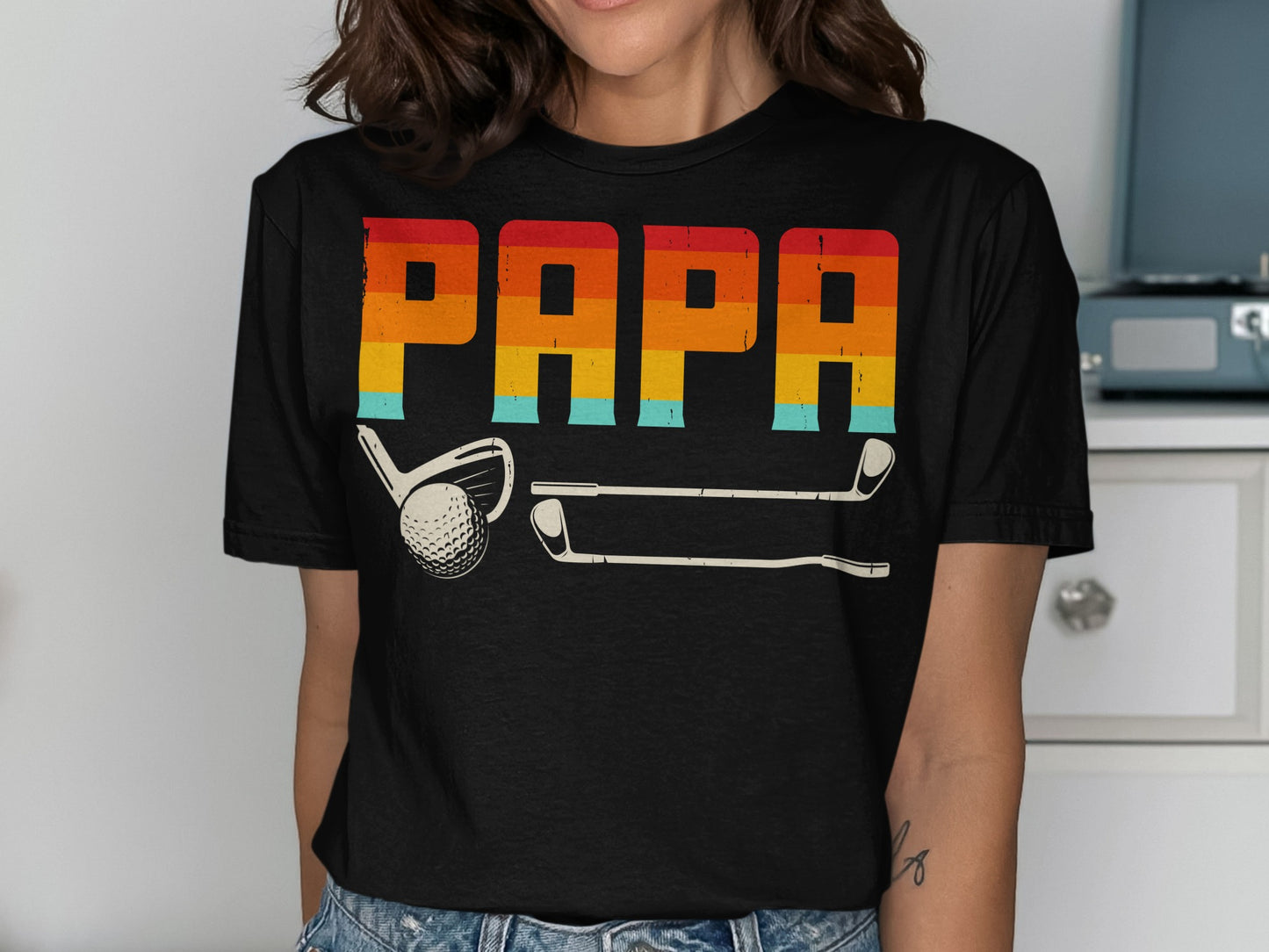 Black t-shirt with "PAPA" in retro rainbow stripes and golf clubs.