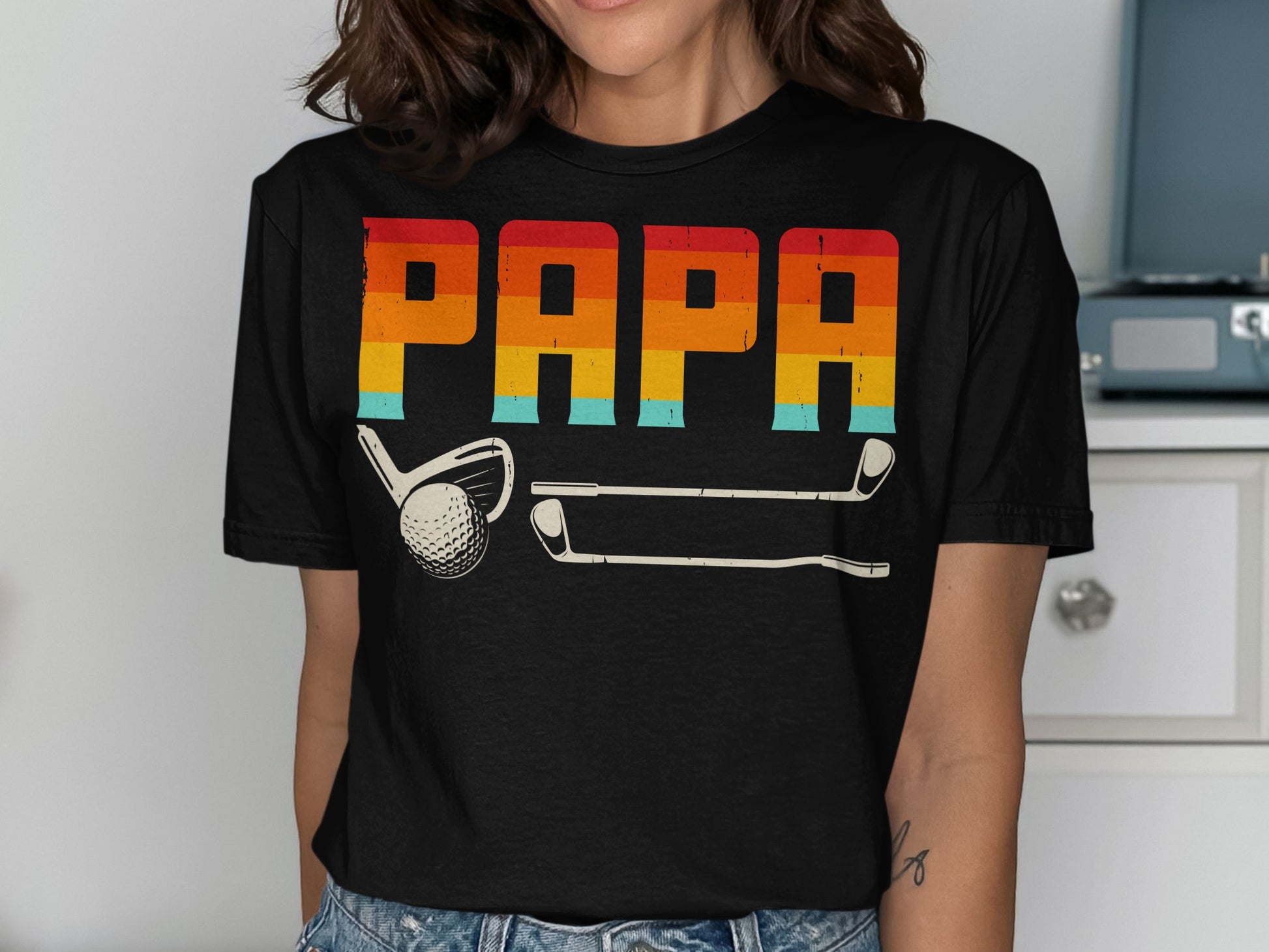 Black t-shirt with "PAPA" in retro rainbow stripes and golf clubs.