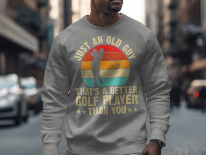 Gray sweatshirt with "Just an old guy, that's a better golfer than you" text and golfer graphic.