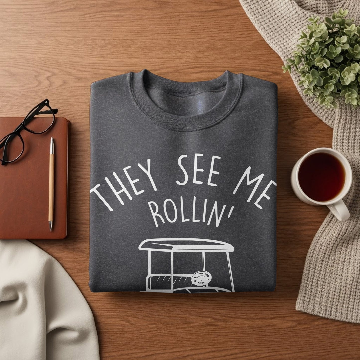 Dark gray crewneck sweatshirt with "They see me rollin'" and golf cart graphic.