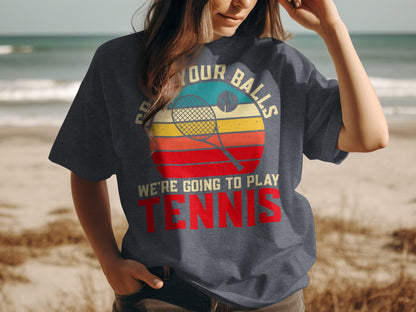 Woman wearing a dark t-shirt with "Put Your Balls We're Going to Play Tennis" text.