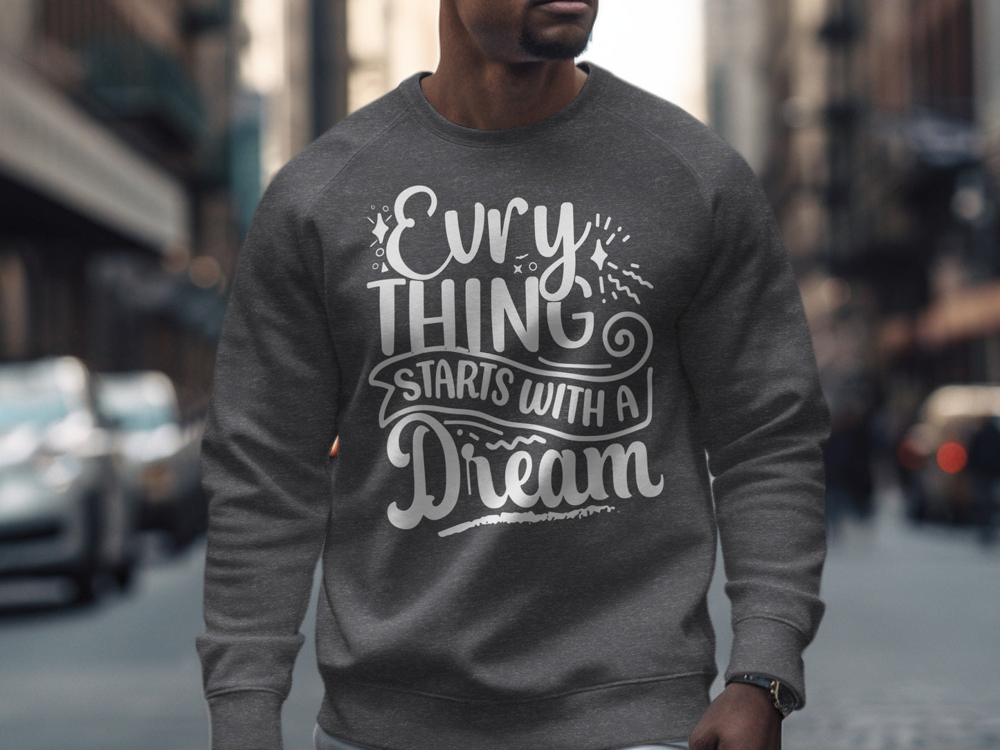 Grey sweatshirt with "Everything Starts With a Dream" text in white script.