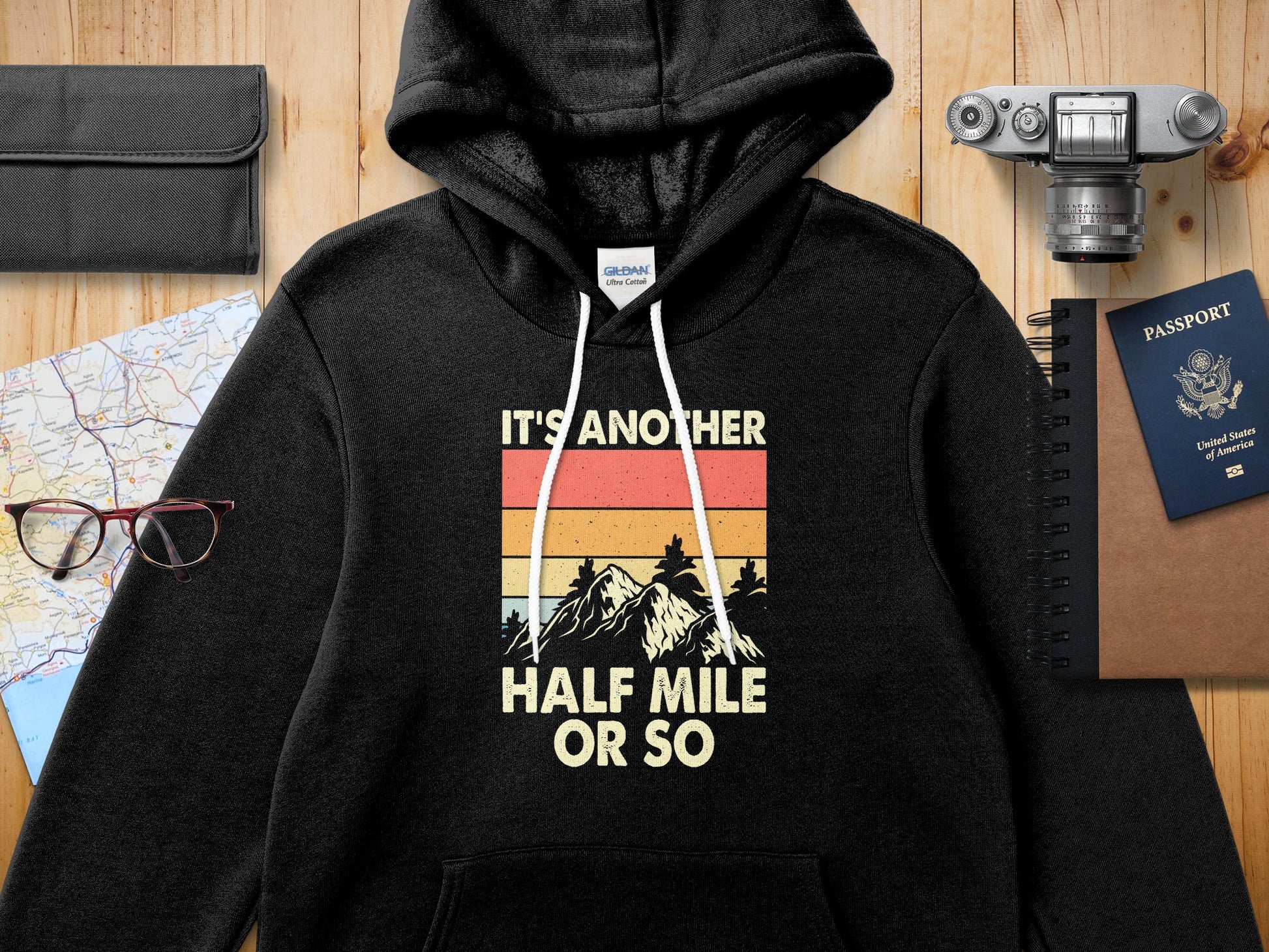 Black hoodie with "IT'S ANOTHER HALF MILE OR SO" mountain graphic.