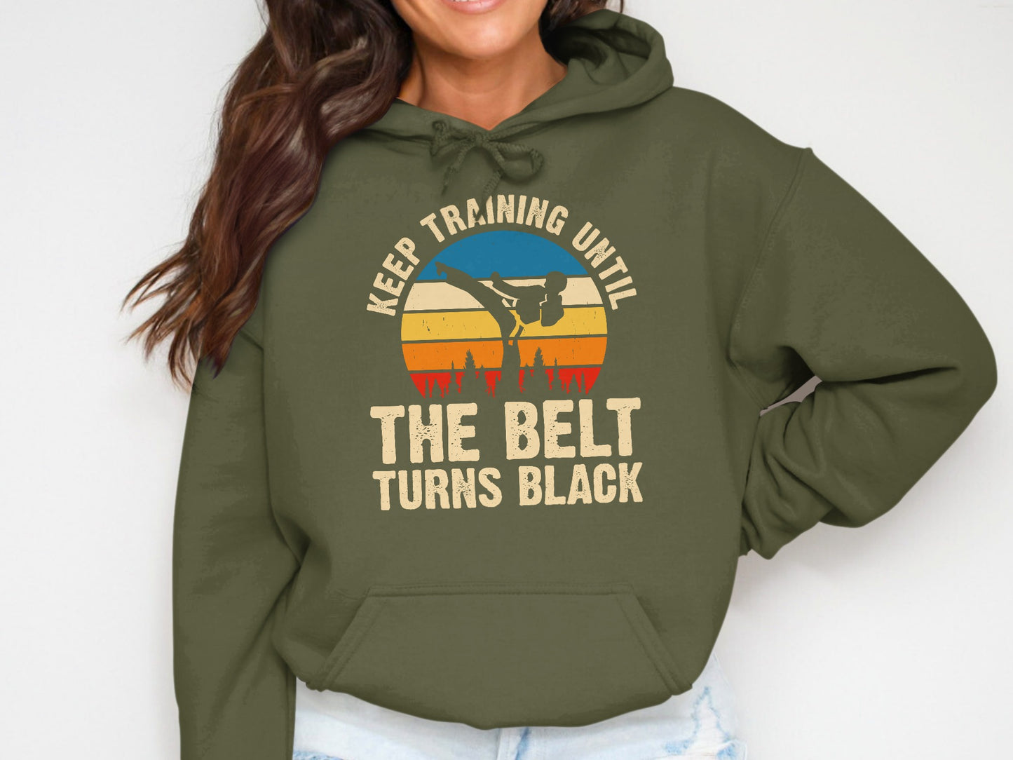Green hoodie with sunset graphic and text "Keep training until the belt turns black."