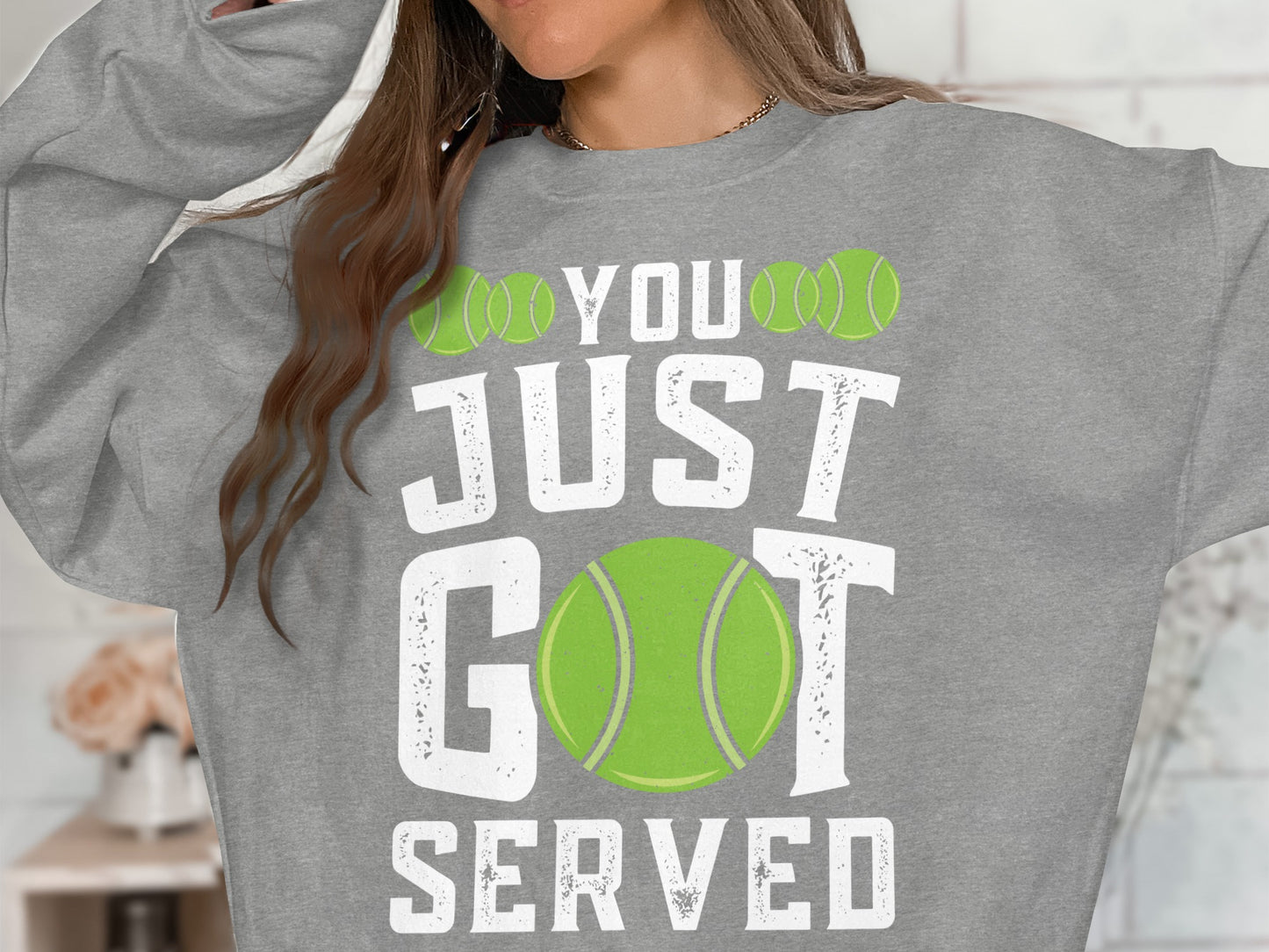 Grey sweatshirt with "YOU JUST GOT SERVED" and tennis balls graphic.
