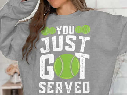 Grey sweatshirt with "YOU JUST GOT SERVED" and tennis balls graphic.