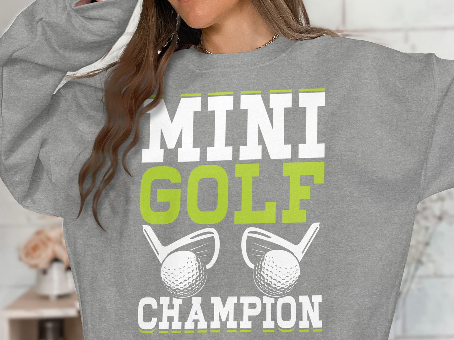 Grey sweatshirt with "MINI GOLF CHAMPION" and golf clubs and balls.