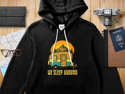 Black hoodie with a retro camper and sunset graphic and "We Sleep Around" text.