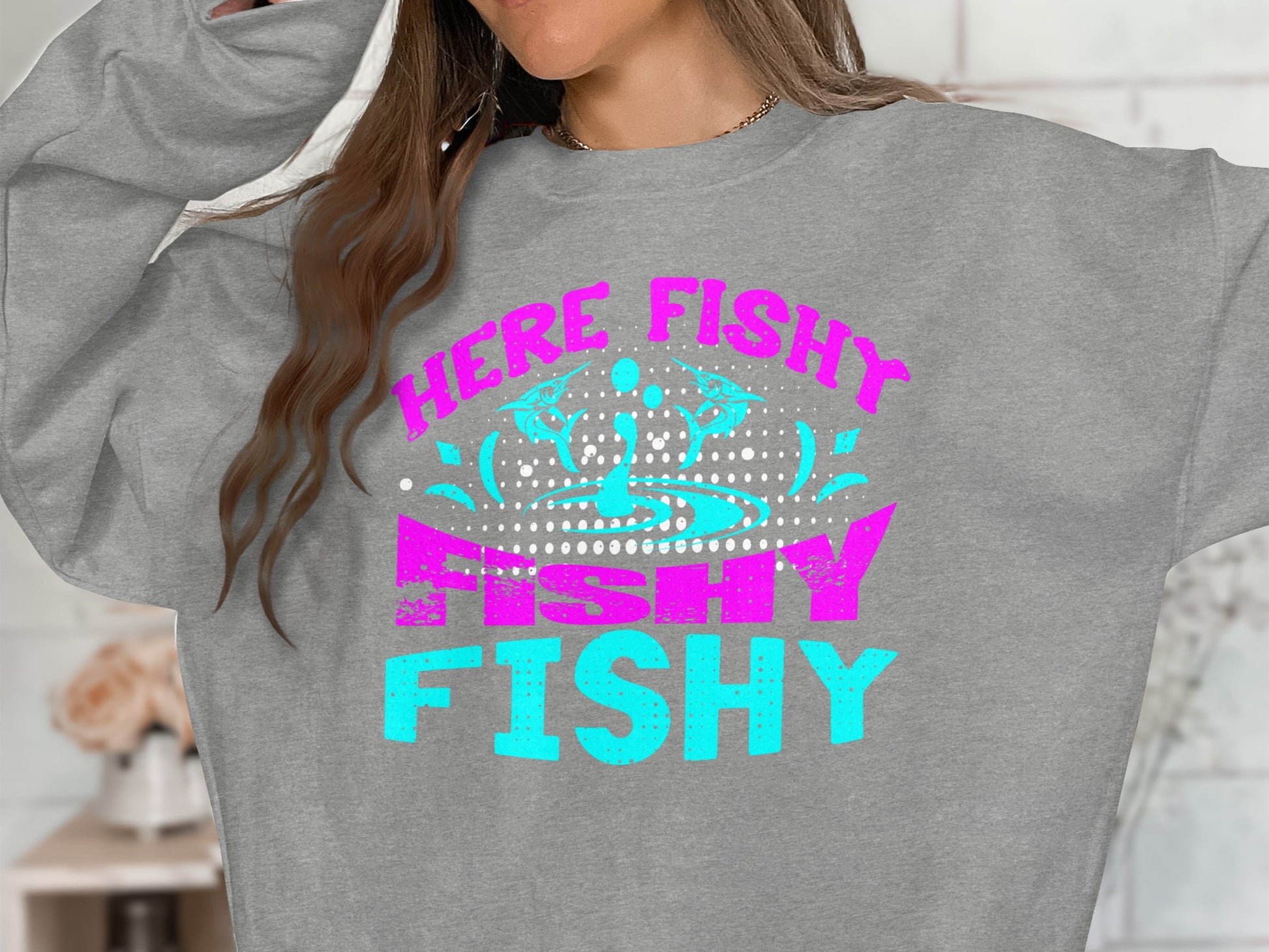 Grey sweatshirt with "WE'RE FISHY FISHY" text in teal and pink.