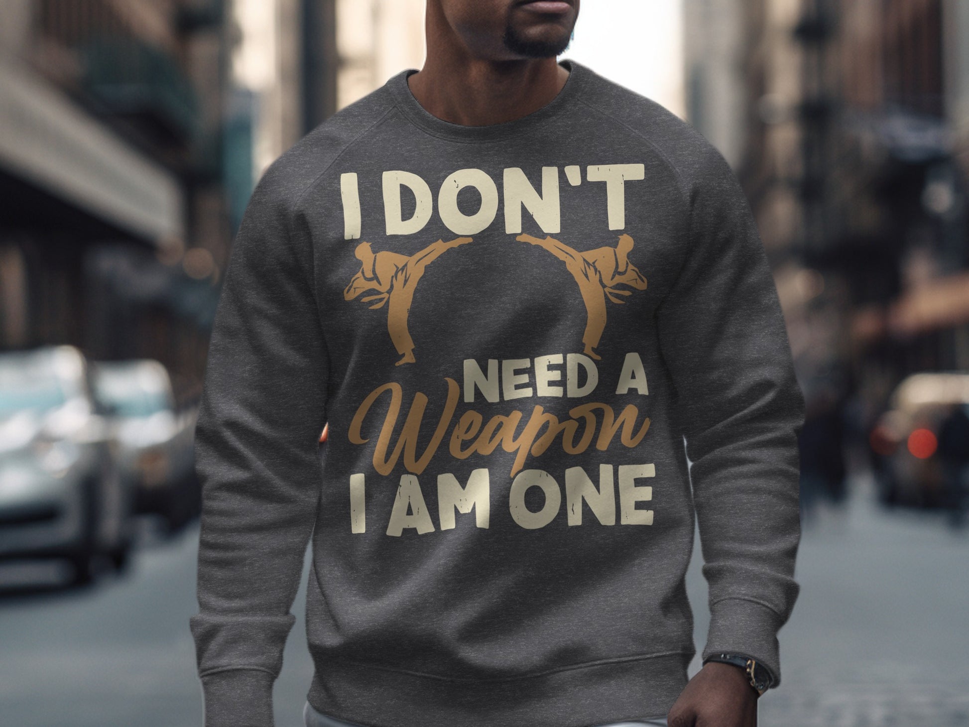 Gray sweatshirt with "I DON'T NEED A WEAPON I AM ONE" text and martial arts graphics.