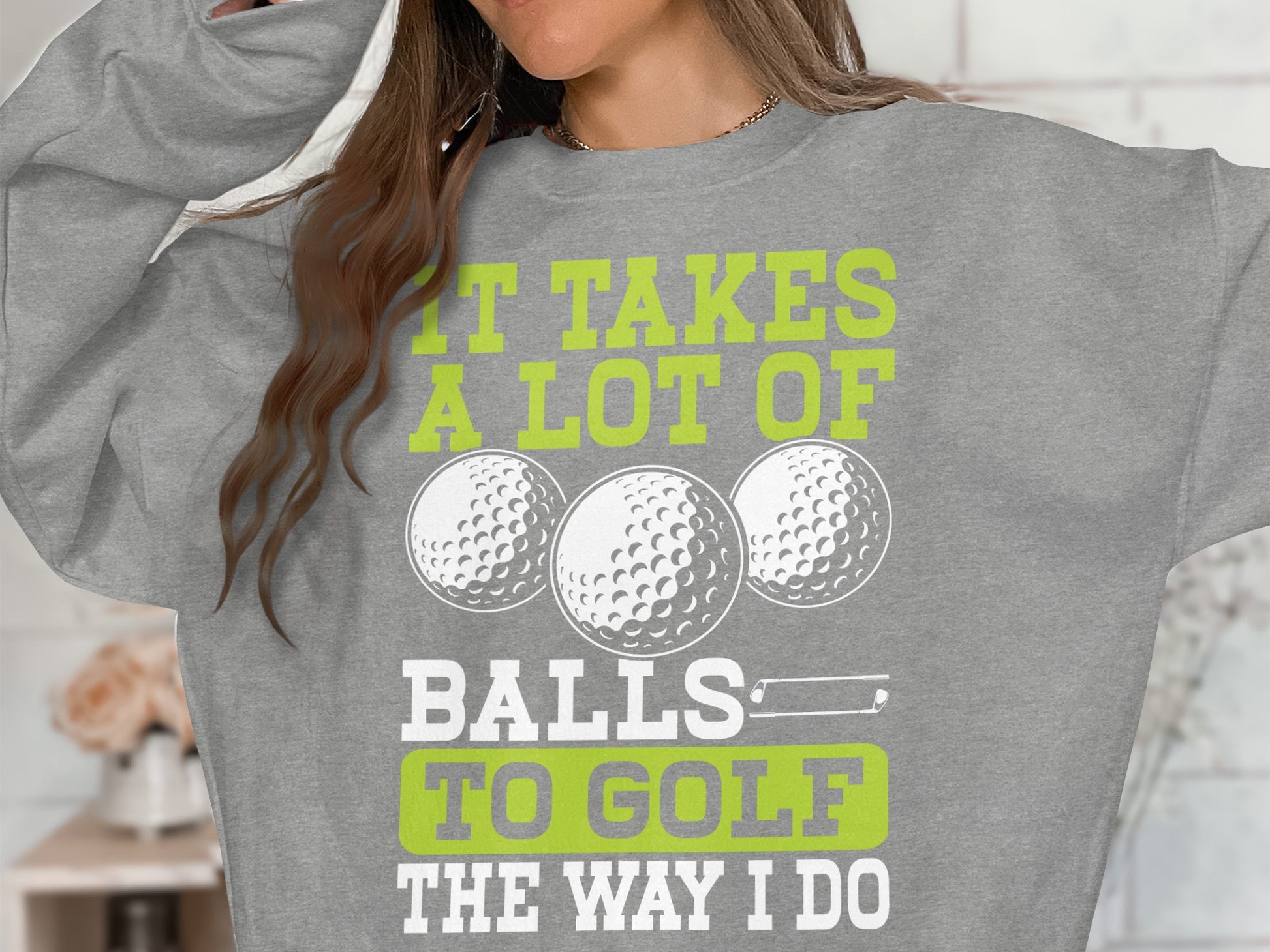Gray sweatshirt with text "IT TAKES A LOT OF BALLS TO GOLF THE WAY I DO" and golf balls.