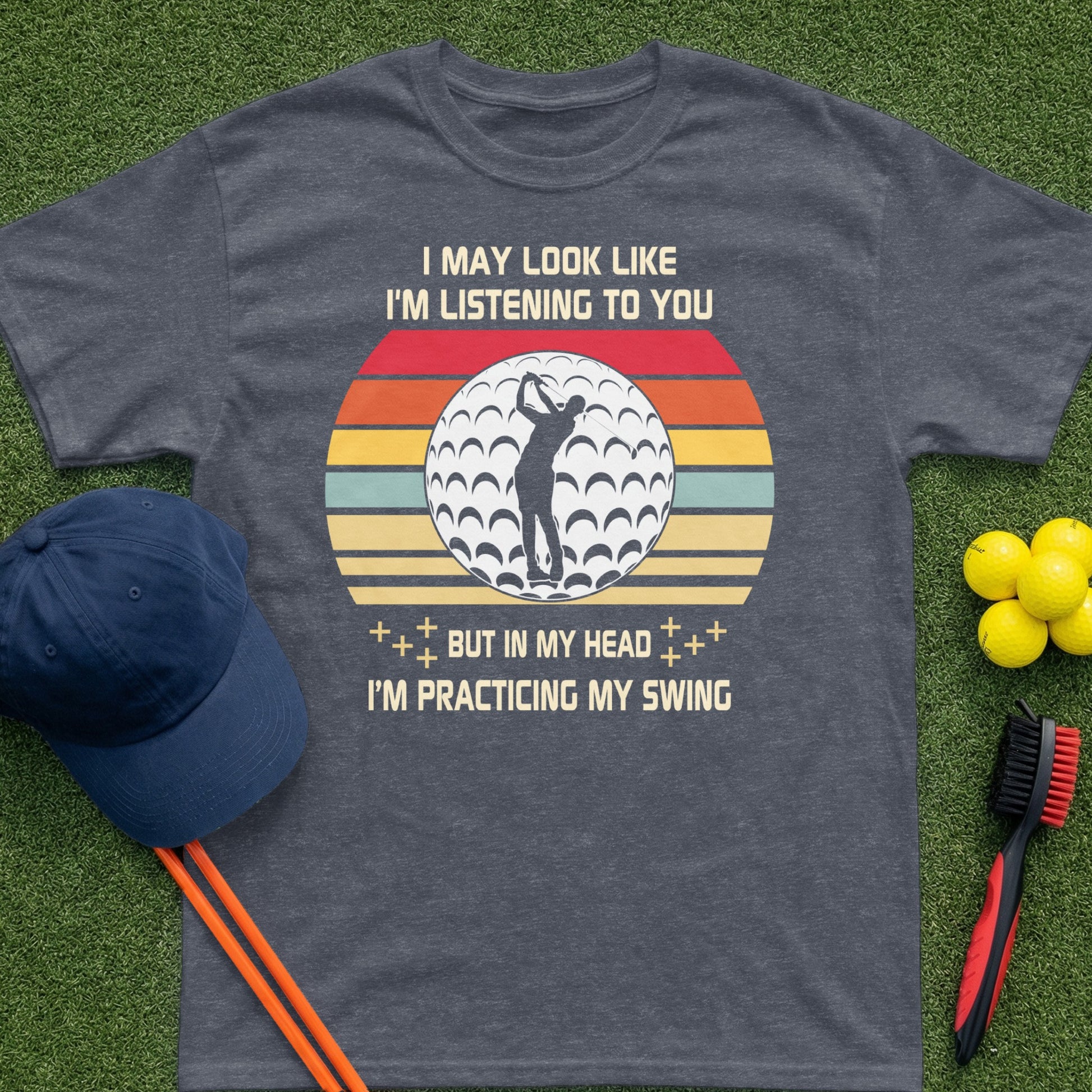 T-shirt with golf ball, stripes, and text about practicing a swing.