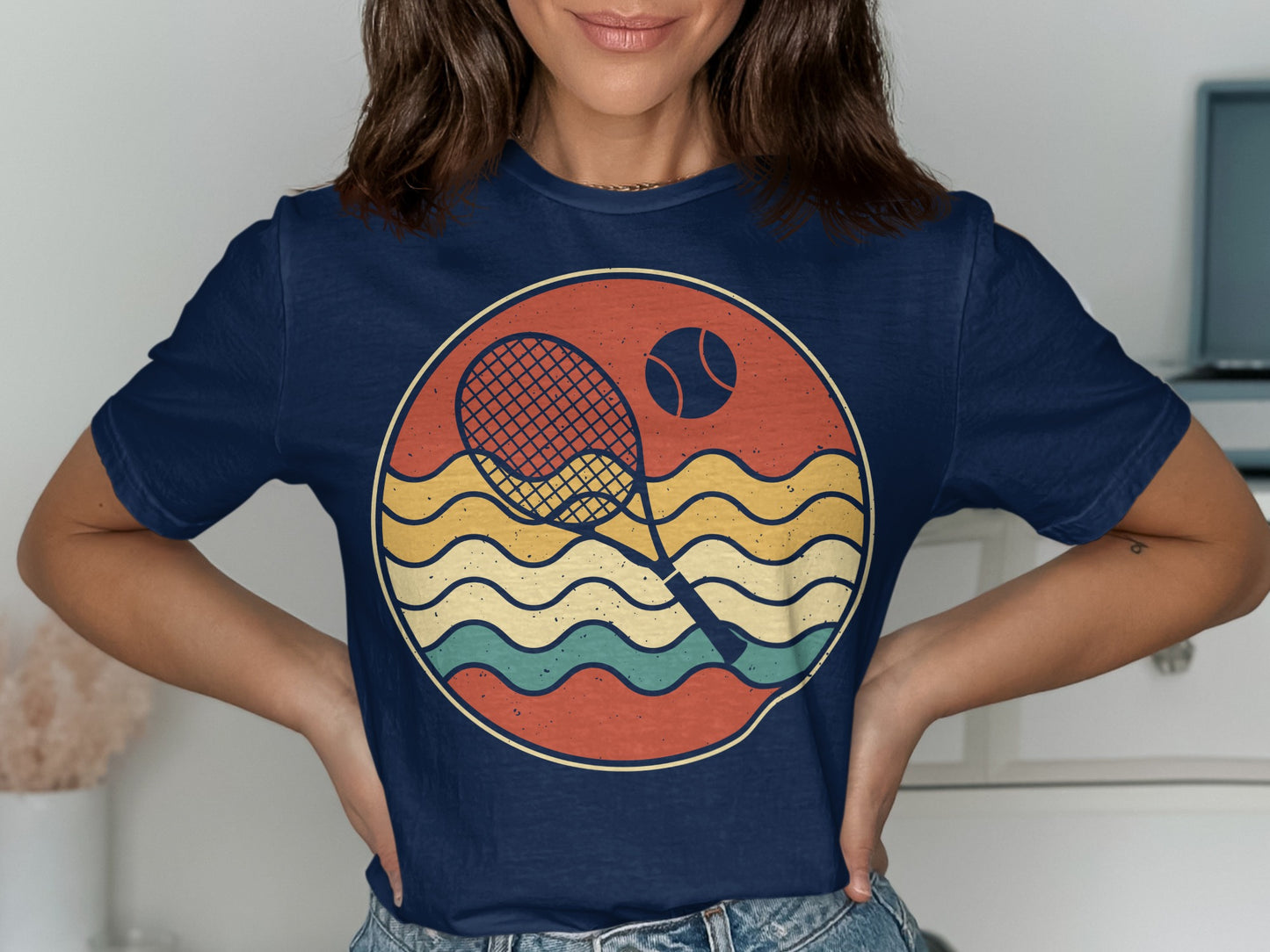 Navy t-shirt with vintage tennis racket, ball, and wavy lines graphic.