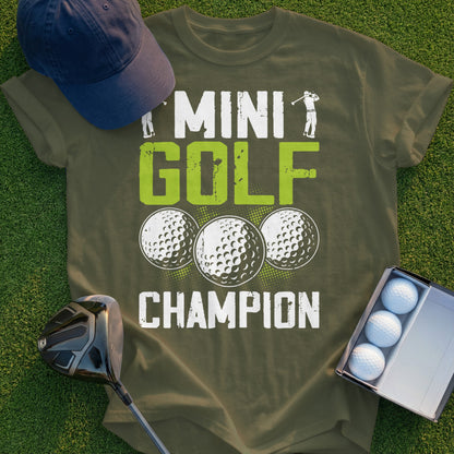 Green t-shirt with "MINI GOLF CHAMPION" and three golf balls.