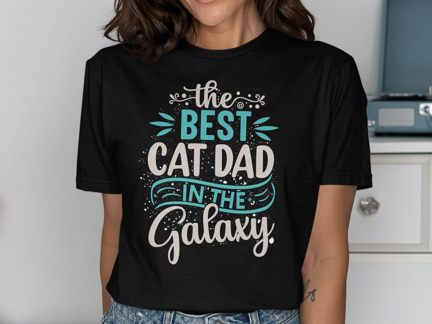 Black t-shirt with "The Best Cat Dad in the Galaxy" text.