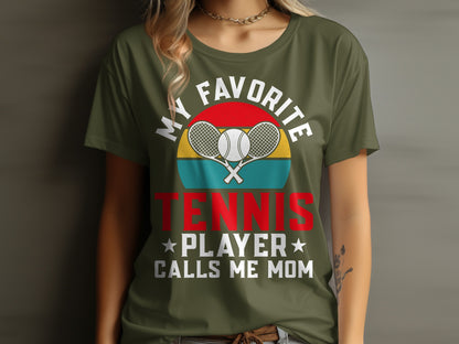 Olive green t-shirt with "MY FAVORITE TENNIS PLAYER CALLS ME MOM" text and rackets.