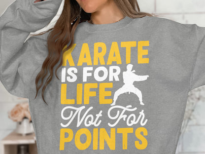 Grey sweatshirt with "Karate is for life, not for points" text and karate graphic.
