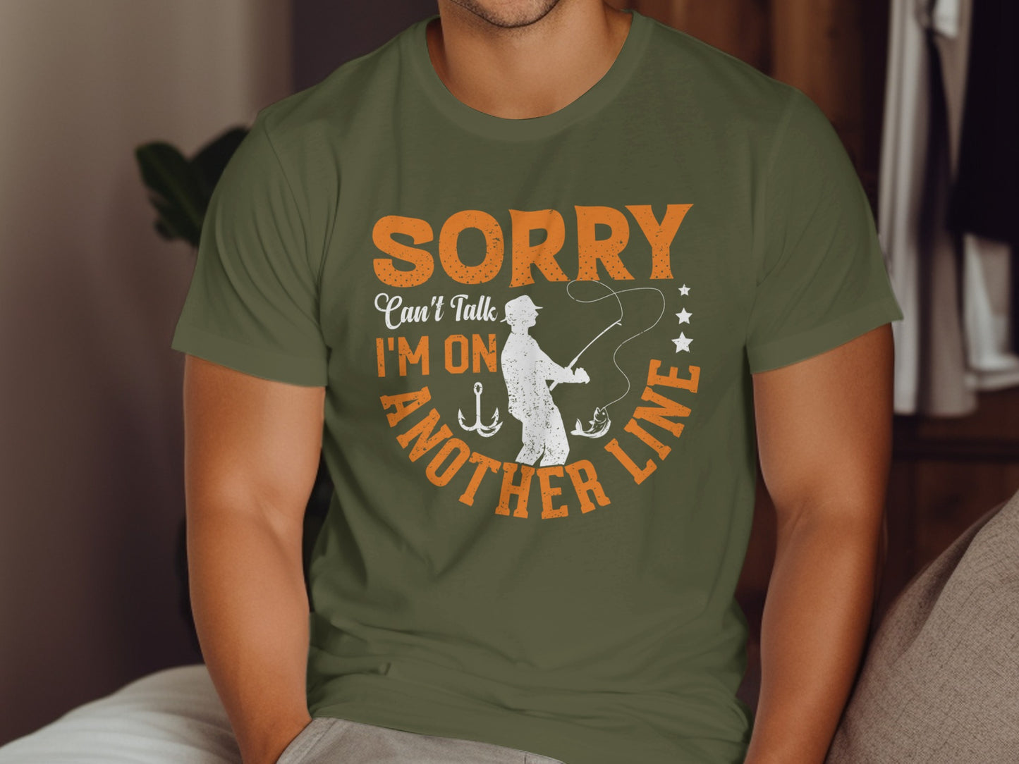 Green t-shirt with text "Sorry, I can't talk, I'm on another line" and fishing graphic.