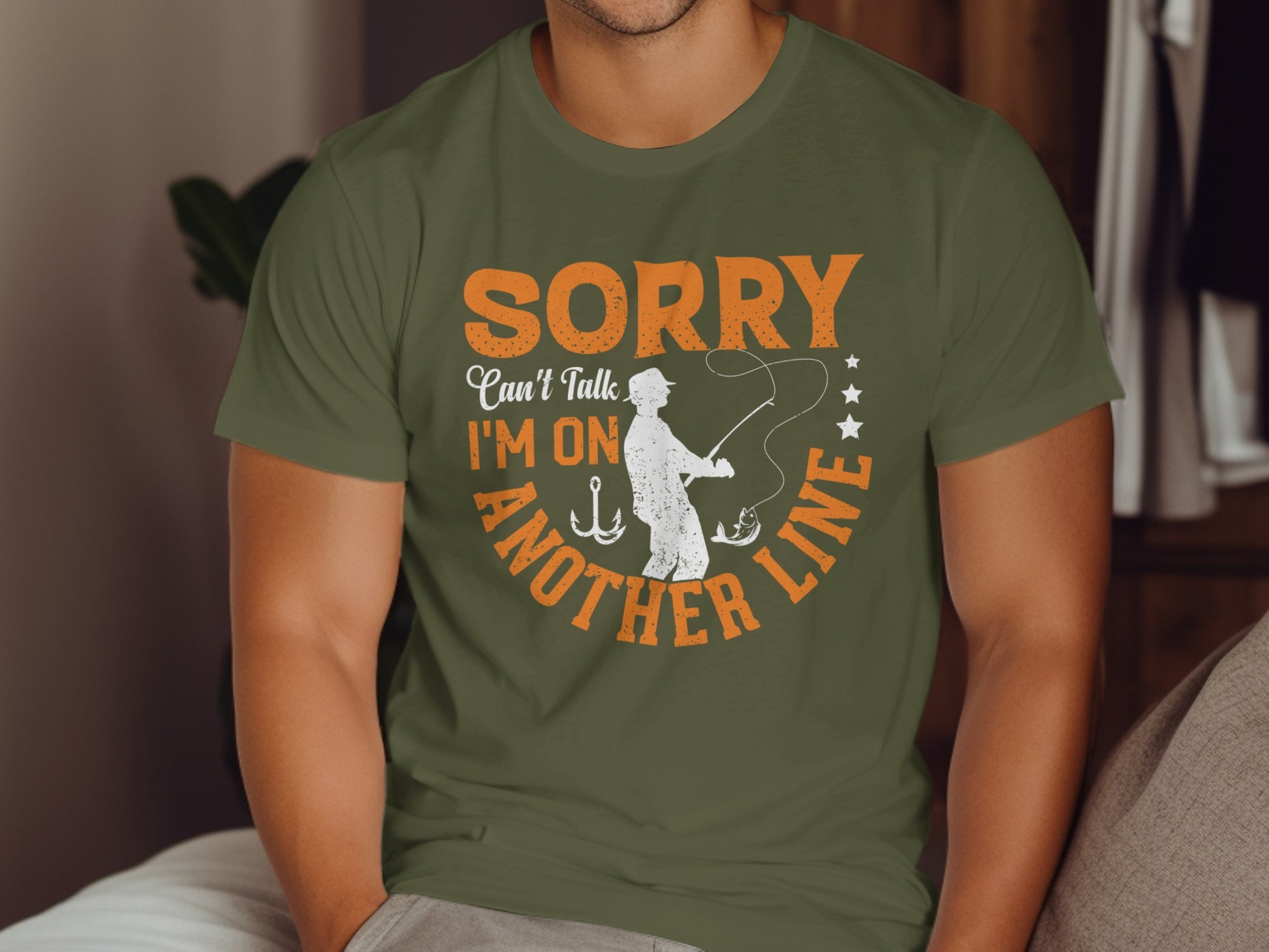 Green t-shirt with text "Sorry, I can't talk, I'm on another line" and fishing graphic.