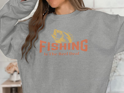 Gray sweatshirt with orange "FISHING Is The Reel Deal" text and fish graphic.