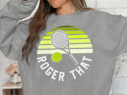Grey sweatshirt with "Roger That" text and tennis racket and ball graphic.