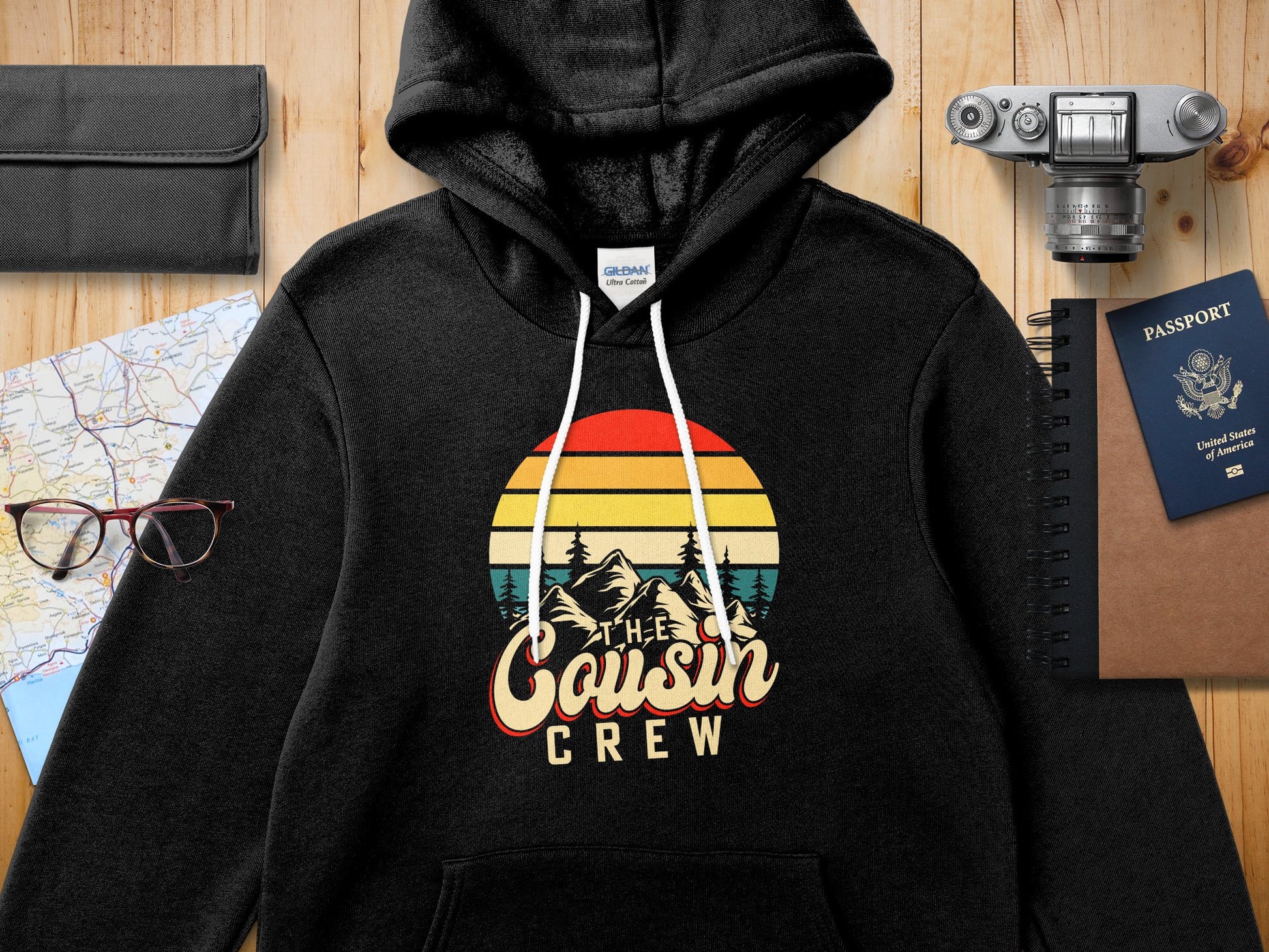 Black hooded sweatshirt with "The Cousin Crew" retro sunset graphic.