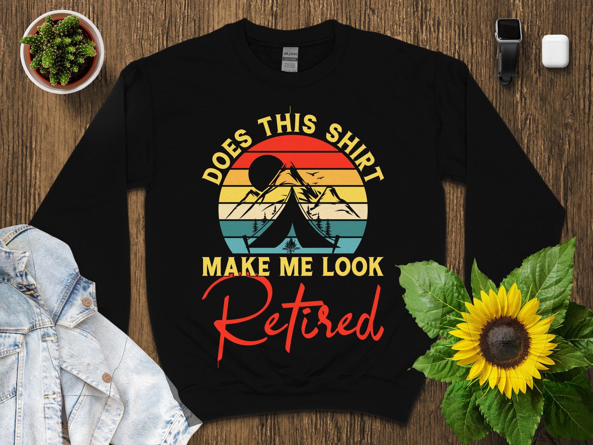 Black sweatshirt with "Does This Shirt Make Me Look Retired" text and mountain graphic.