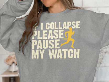 Grey sweatshirt with text "If I Collapse Please Pause My Watch" and a running figure.