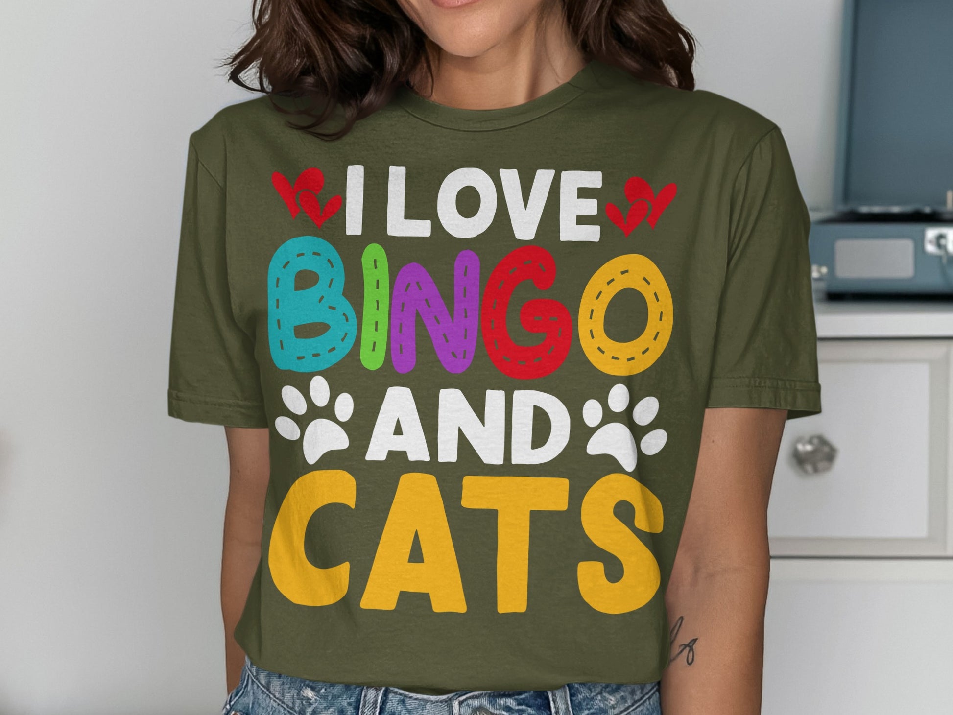 Green t-shirt with colorful "I LOVE BINGO AND CATS" text and paw prints.