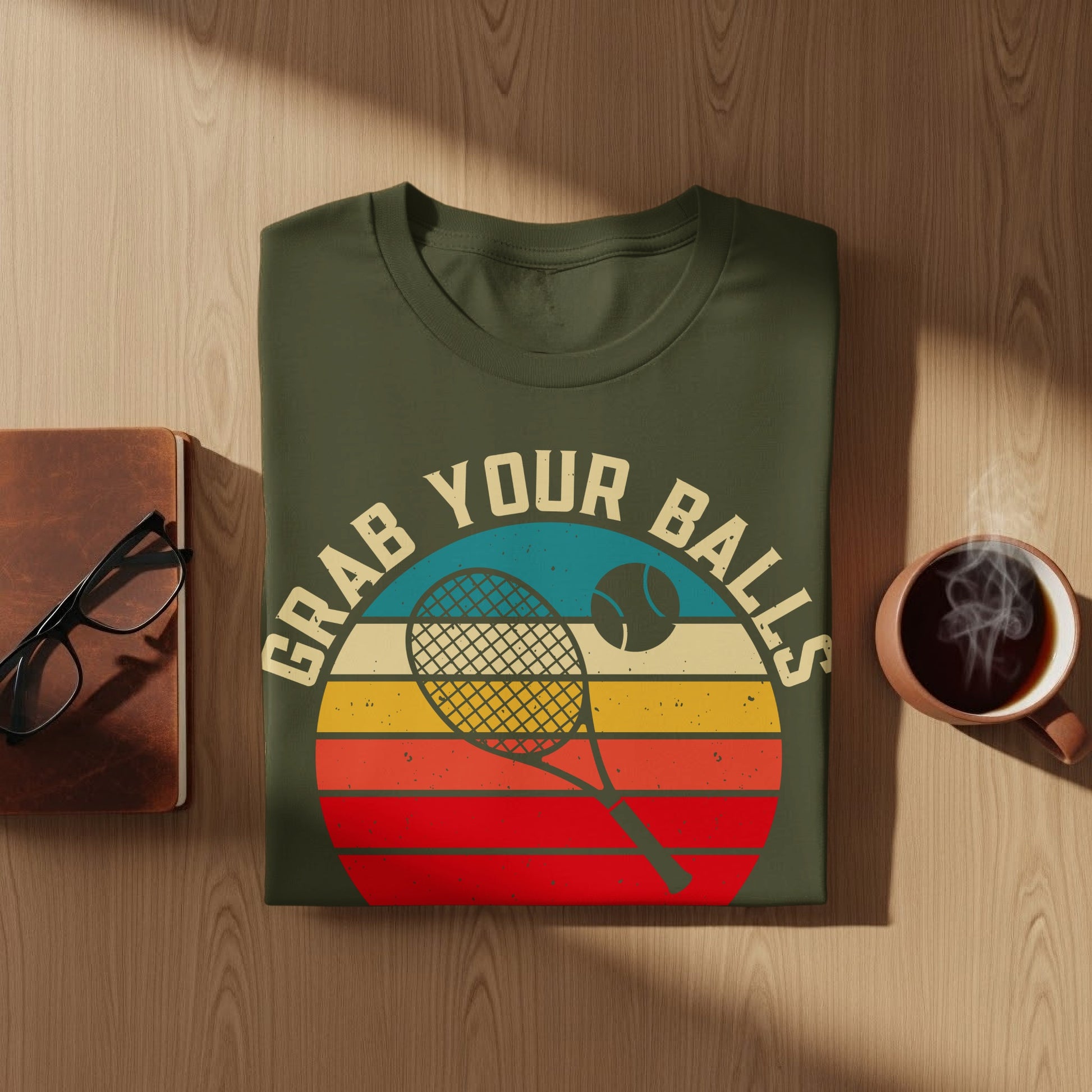 Green t-shirt with "Grab Your Balls" and tennis graphic on striped background.