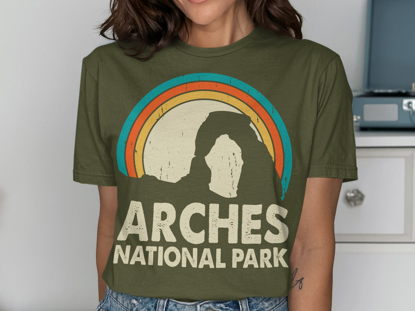 Green t-shirt with vintage Arches National Park rainbow arch design.
