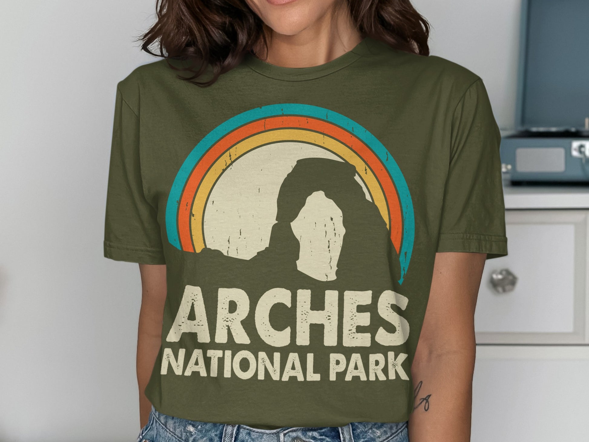 Green t-shirt with vintage Arches National Park rainbow arch design.