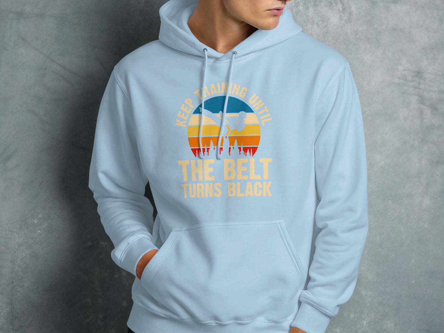 Light blue hoodie with "Keep training until the belt turns black" graphic.