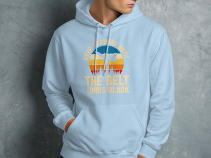 Light blue hoodie with "Keep training until the belt turns black" graphic.