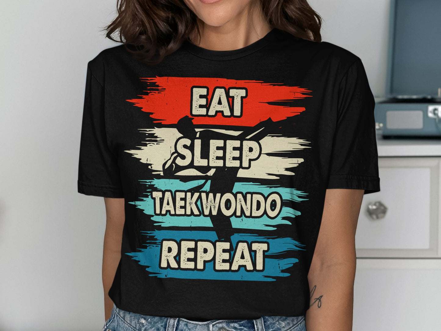 Black t-shirt with "Eat Sleep Taekwondo Repeat" and graphic of a taekwondo kick.