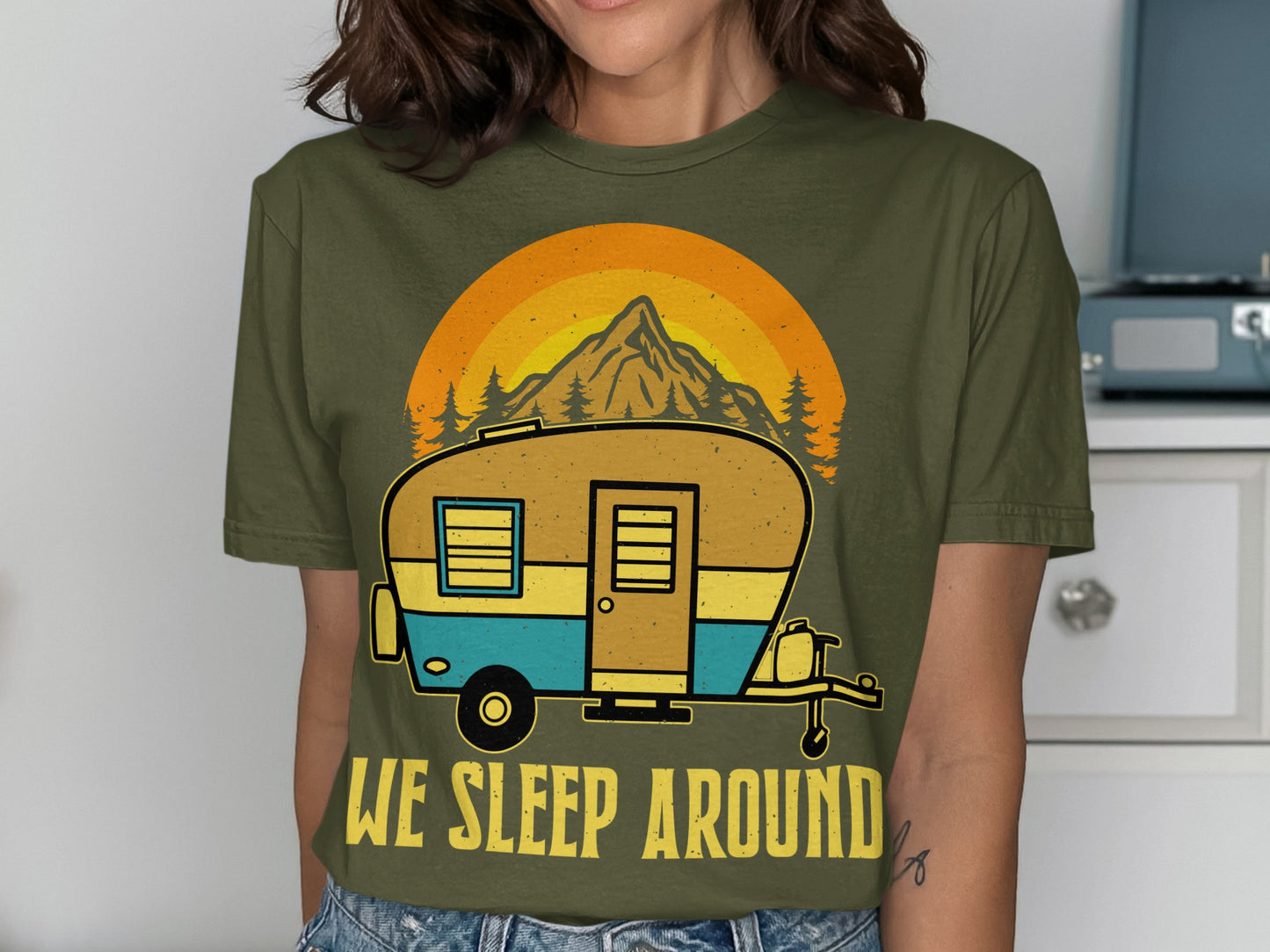 Green t-shirt with a retro camper graphic and "We Sleep Around" text.