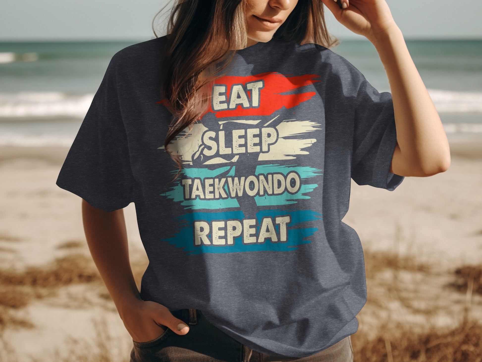 T-shirt with "Eat Sleep Taekwondo Repeat" text on beach background.