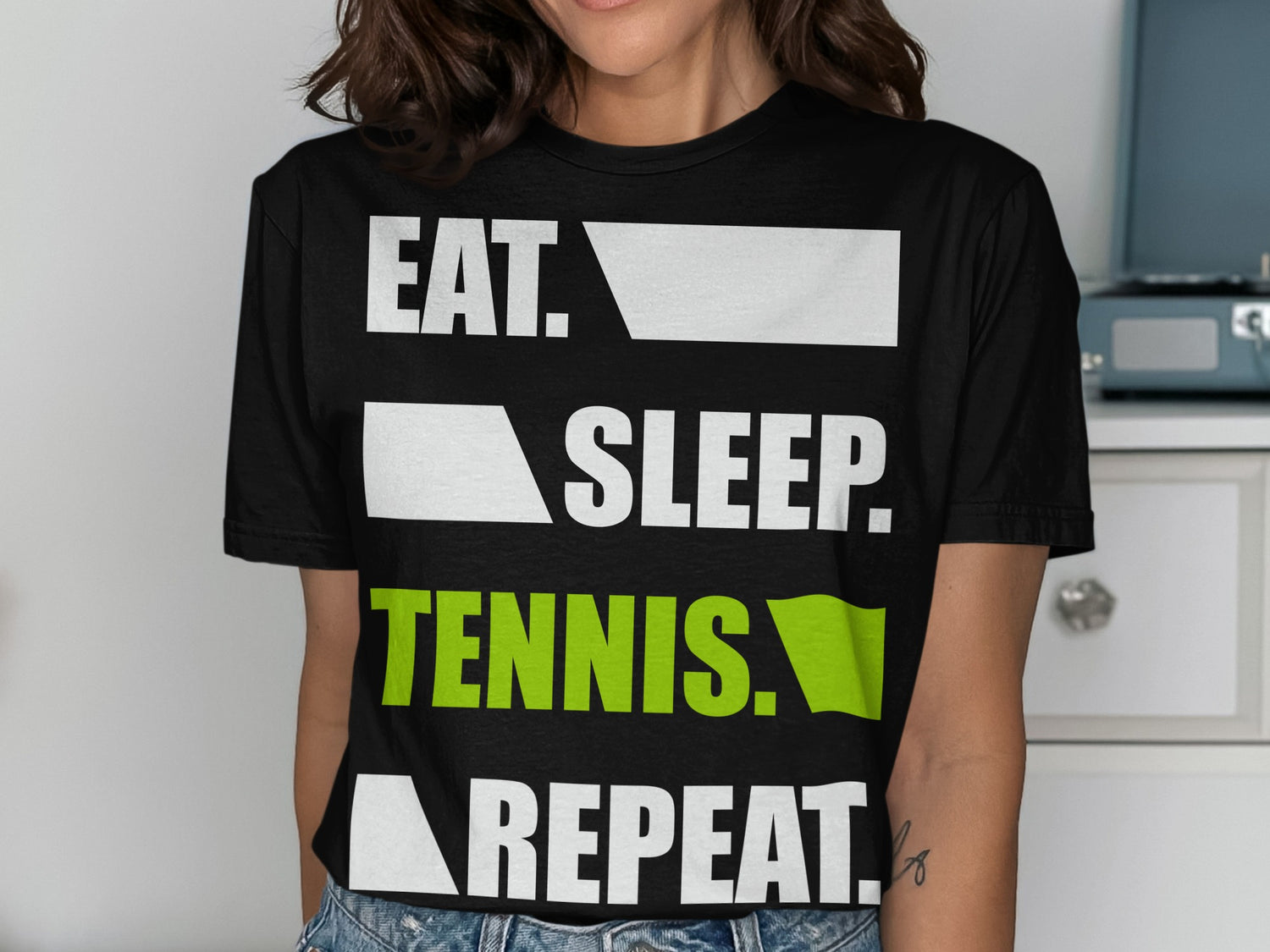 Black t-shirt with "EAT. SLEEP. TENNIS. REPEAT." text in white and green.