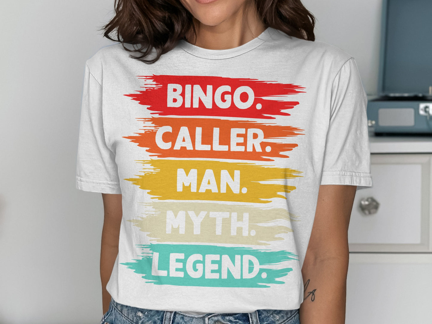 White t-shirt with "Bingo. Caller. Man. Myth. Legend." text in colorful brushstrokes.