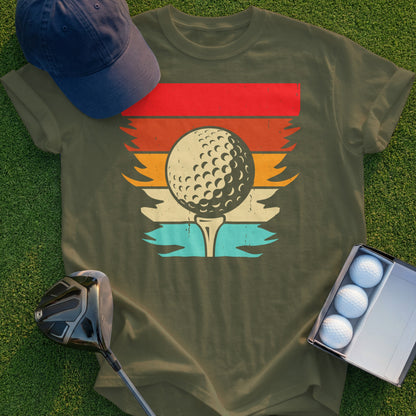 Golf ball on tee with retro sunset graphic, next to golf club and balls.