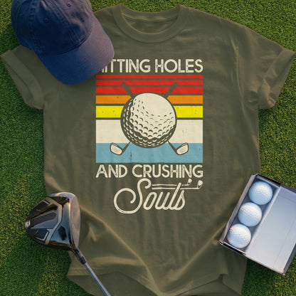 T-shirt with golf ball, clubs, and retro sunset graphic.