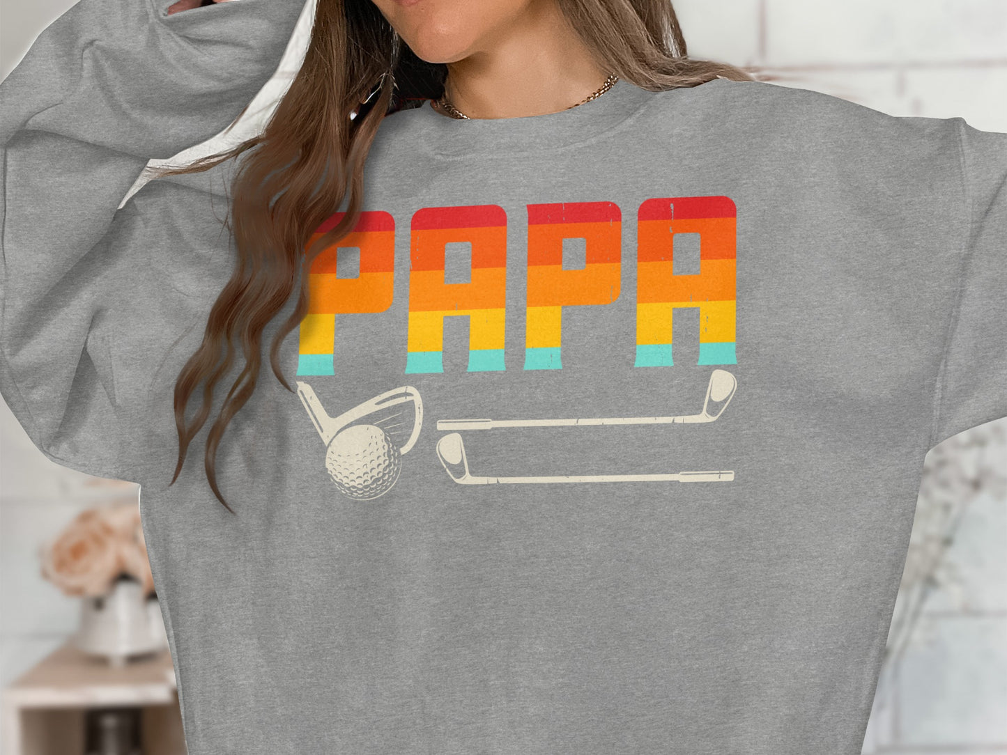 Grey sweatshirt with "PAPA" in retro stripes and golf club and ball graphic.