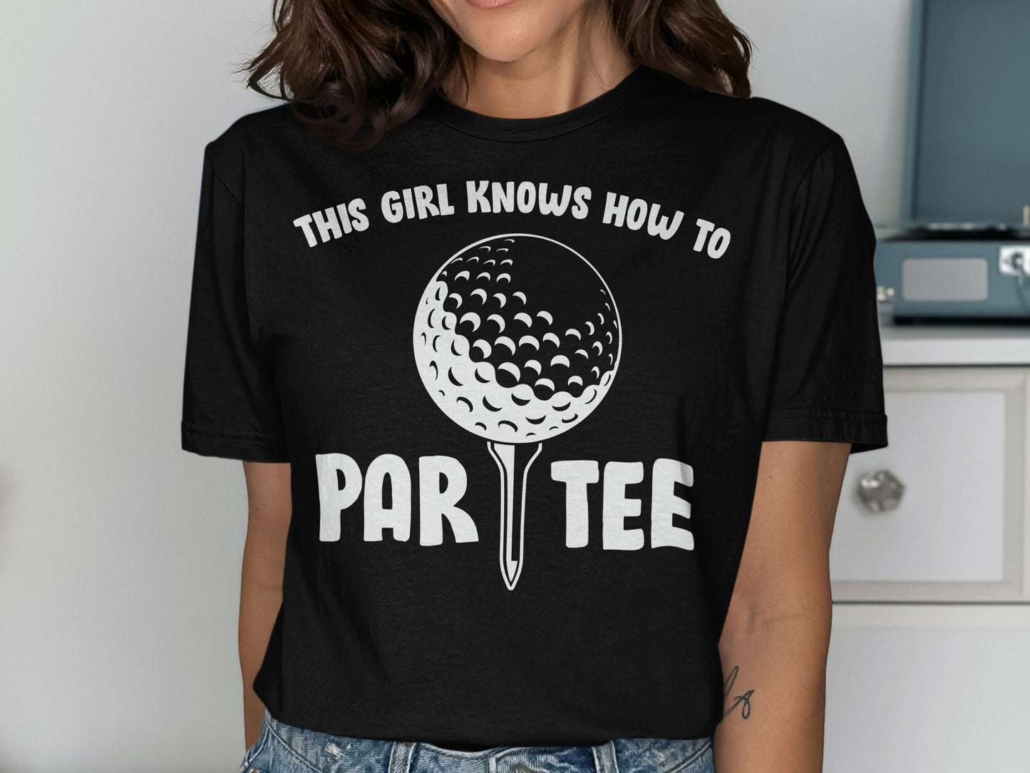 Black t-shirt with "THIS GIRL KNOWS HOW TO PAR TEE" and golf ball graphic.